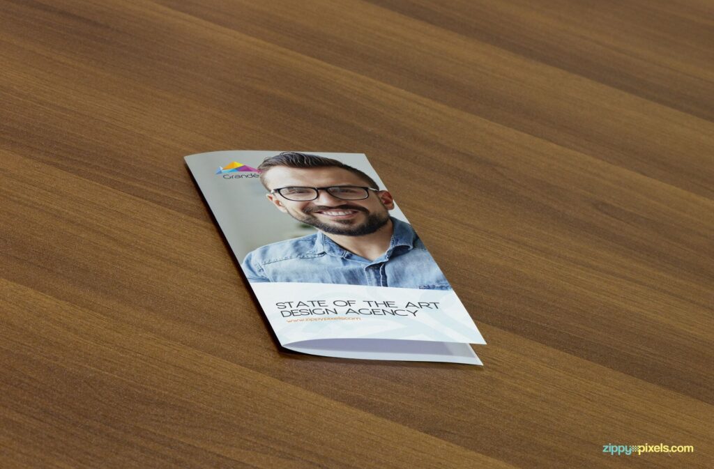 Mockup Displaying a Closed Flyer on a Wooden Table