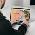 Mockup Featuring a Man Using MacBook Pro on a Table