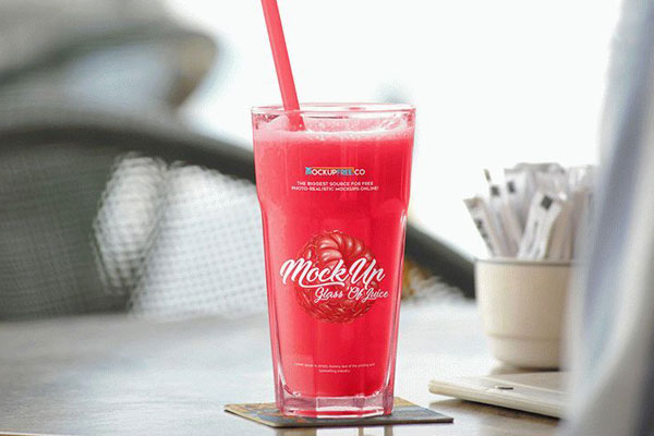 Mockup Featuring Big Glass of Juice on a Table at a Cafe