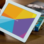 Mockup Featuring Hand Holding iPad on Wooden Table