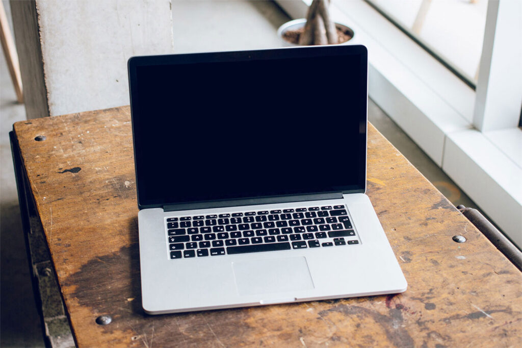 Mockup Featuring Open MacBook Pro on a Wooden Desk