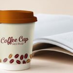 Mockup Featuring Standing Paper Coffee Cup with Book at Background