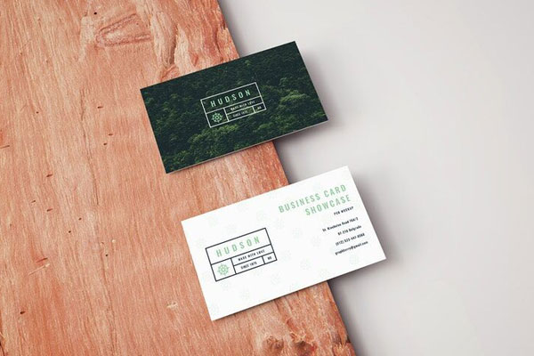 Mockup Featuring Two Business Cards Laid on Wooden Board in Perspective