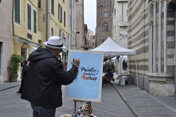 Mockup of a Man Painting on a Canvas in Street