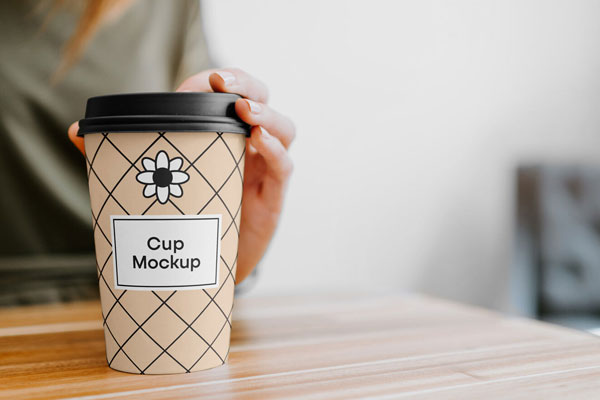 Mockup of Coffee Cup Held By a Woman