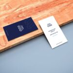 Mockup of Two Business Cards in Perspective Featuring a Wooden Board