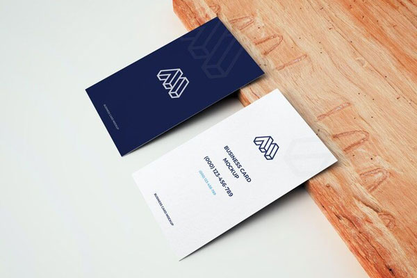 Mockup of Two Business Cards Leaning on Wooden Board in Perspective