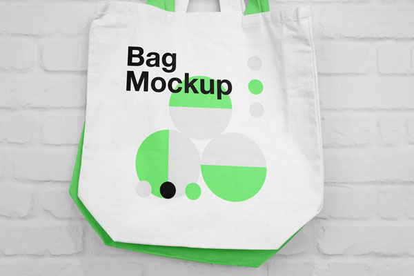 Mockup of Two Canvas Bags Hanging on a Nail