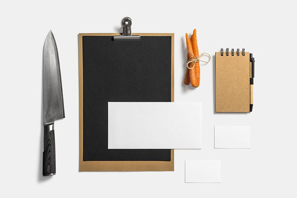 Mockup Showcasing Menu, Business Cards, Notebook Beside Knife and Carrots
