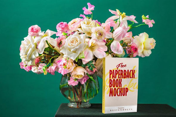 Paperback Book Cover and Spine Mockup on Table with a Glass Vase