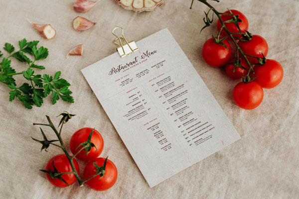 Perspective View A4 Menu Among Food Ingredients on Fabric Mockup