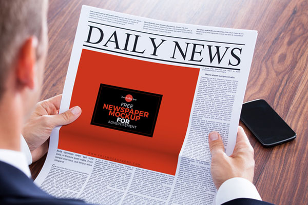 Perspective View of a Newspaper Ad in a Man’s Hands Mockup