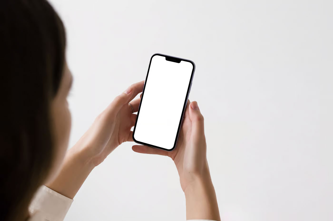 Free Perspective View of iPhone Pro Mockup in Woman Hands PSD Template