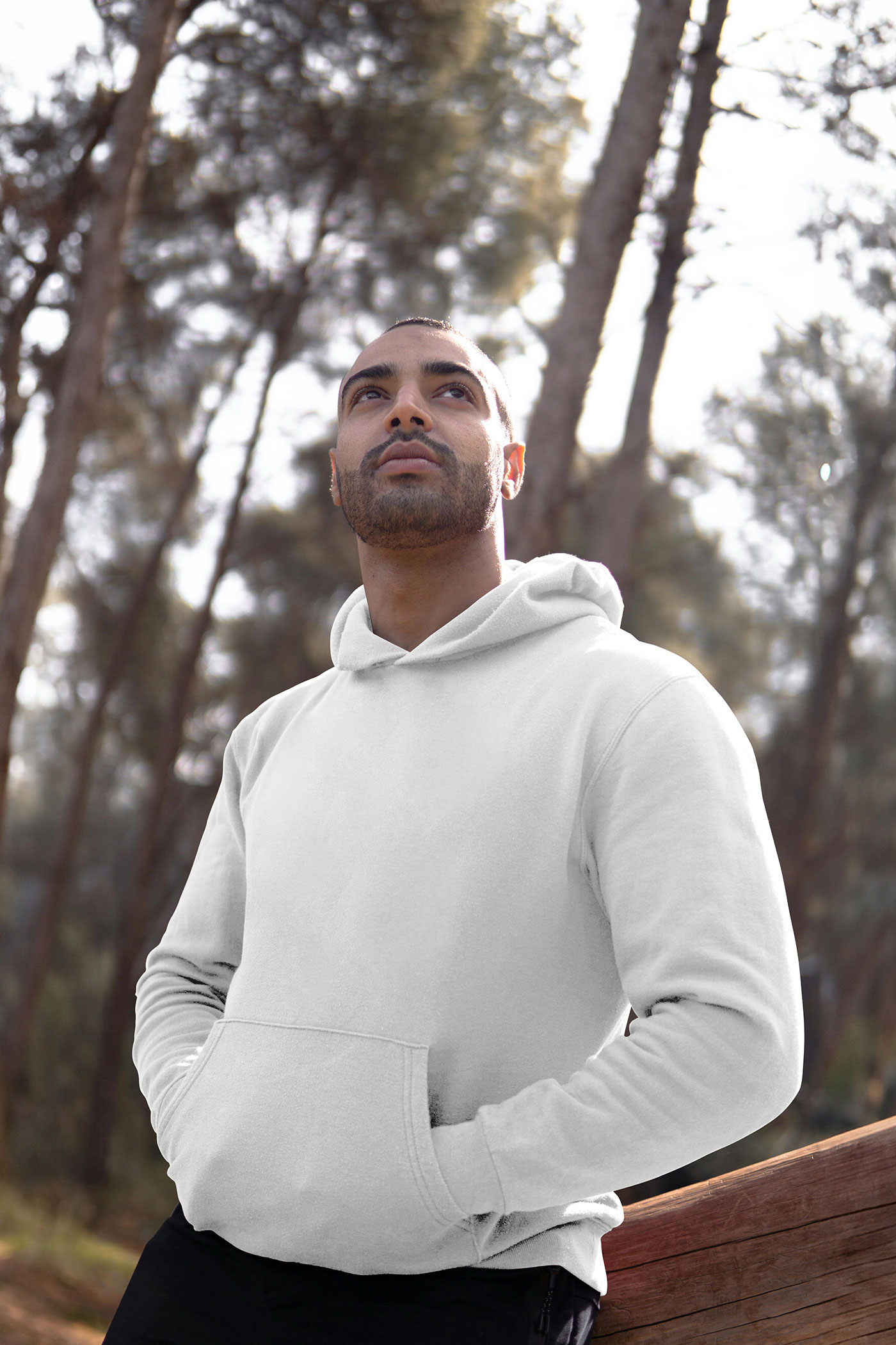 Free Perspective View of Man Wearing Hoodie Mockup Between Woods PSD Template