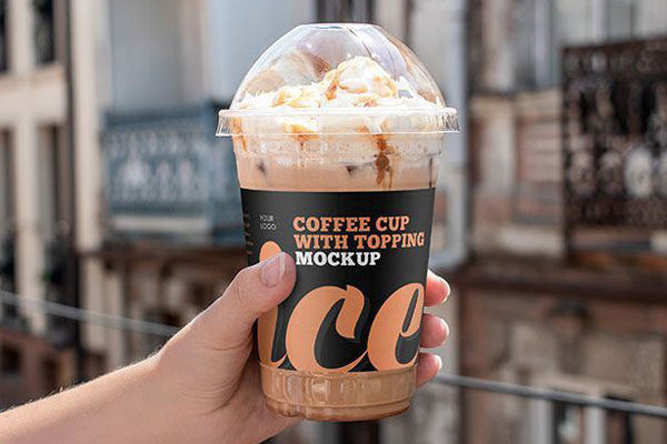 Plastic Cup of Cream Topped Iced Coffee with Lid Holding by Hand Mockup