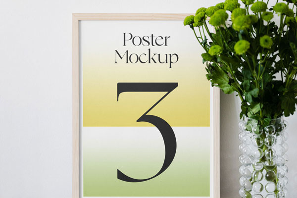 Poster Mockup on Wooden Desk and a Flower on the Right Side