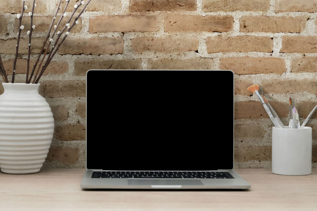 Realistic MacBook Workspace Mockup Against the Brick Wall