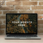 Realistic MacBook Workspace Mockup Against the Brick Wall