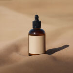 Amber Dropper Bottle Mockup with Sand Background