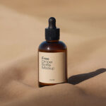 Amber Dropper Bottle Mockup with Sand Background