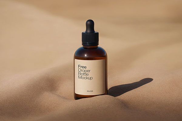 Amber Dropper Bottle Mockup with Sand Background