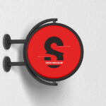 Round Signage Put up on the Wall in Half-Side View Mockup