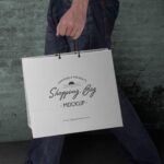 Side View Man Holding a Paper Shopping Bag Mockup