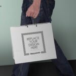 Side View Man Holding a Paper Shopping Bag Mockup