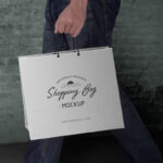 Side View Man Holding a Paper Shopping Bag Mockup