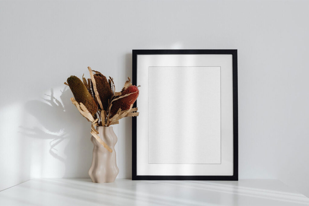 Simple Frame on the Desk Mockup Next to a Flower