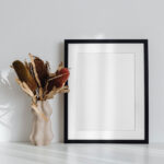 Simple Frame on the Desk Mockup Next to a Flower