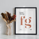 Simple Frame on the Desk Mockup Next to a Flower