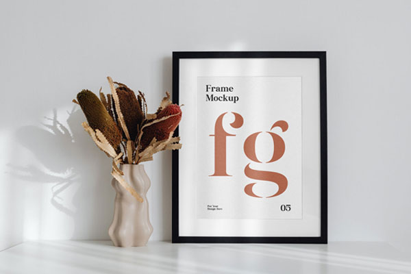 Simple Frame on the Desk Mockup Next to a Flower