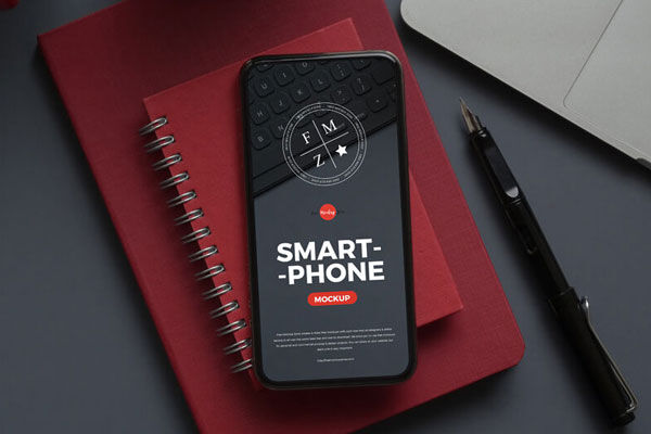 Smartphone Mockup Laid on Notebook in Top View