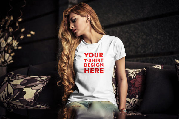 T-Shirt Mockup of Young Woman Sitting on Sofa