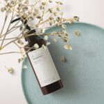 Top View Cosmetics Bottle Mockup on Tray with Flowering Plant