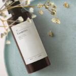 Top View Cosmetics Bottle Mockup on Tray with Flowering Plant