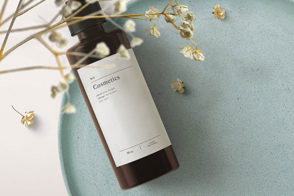Top View Cosmetics Bottle Mockup on Tray with Flowering Plant