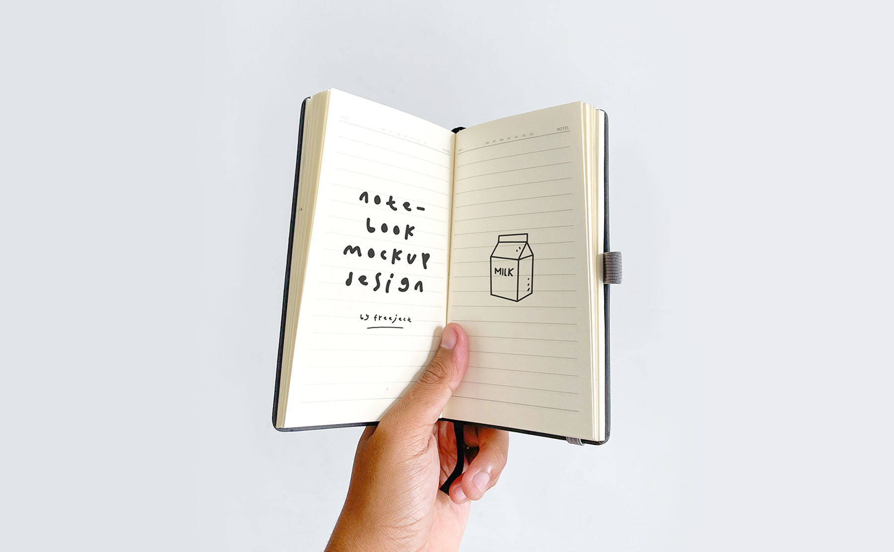 Top View Hand Holing Small Notebook Mockup in Plain Setting FREE PSD
