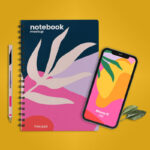 Top View of a Notebook with iPhone 12 and a Pen Mockup