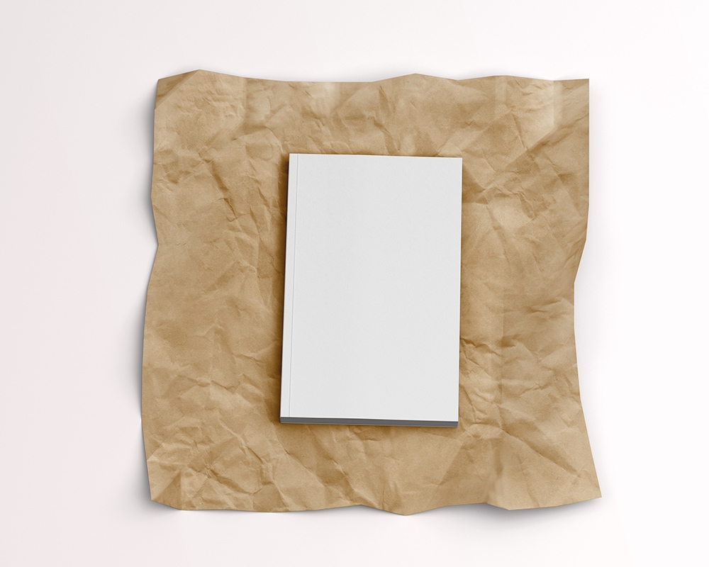 Top View of a Softcover Book on a Wrinkled Paper Mockup