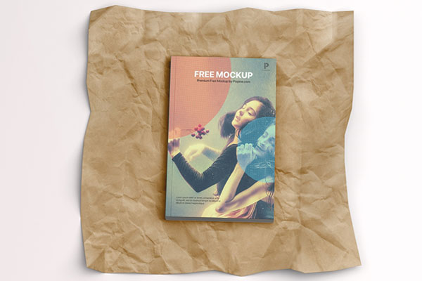 Top View of a Softcover Book on a Wrinkled Paper Mockup