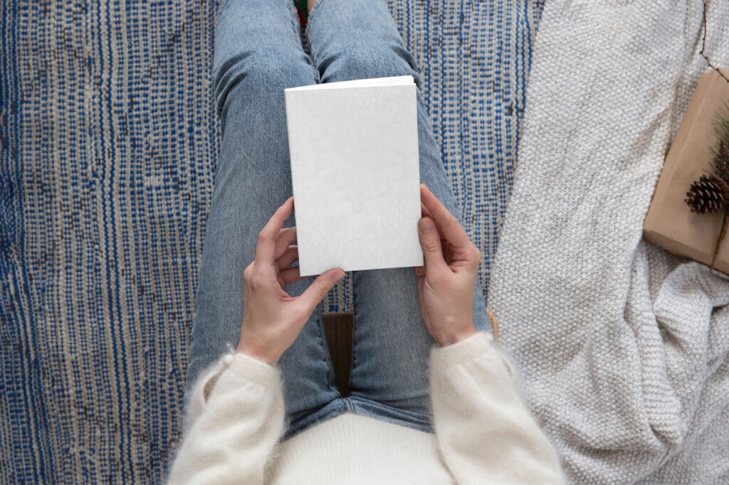 Top View of a Woman Holding Book Cover Mockup
