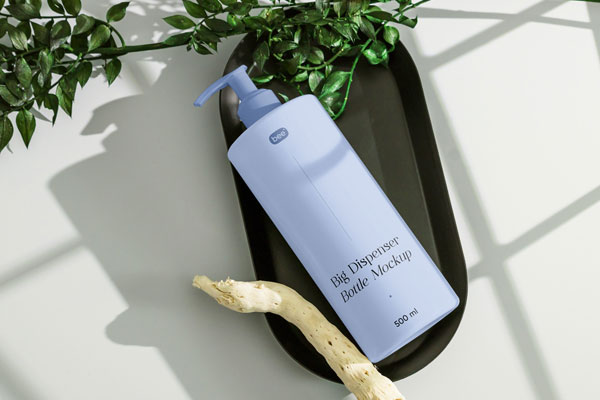 Top View of Realistic Lying Dispenser Bottle Mockup with Plant