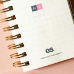 Top View of Vertical Spiral Notebook Mockup with Scrambled Papers