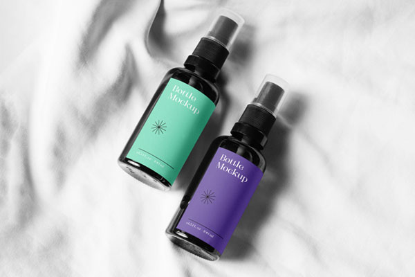 Two Small Spray Bottle on a Soft Sheet Mockup