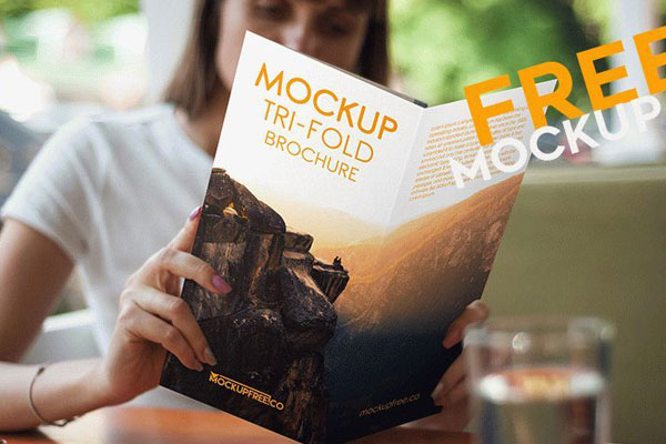 Woman Reading a Tri-Fold Brochure Mockup